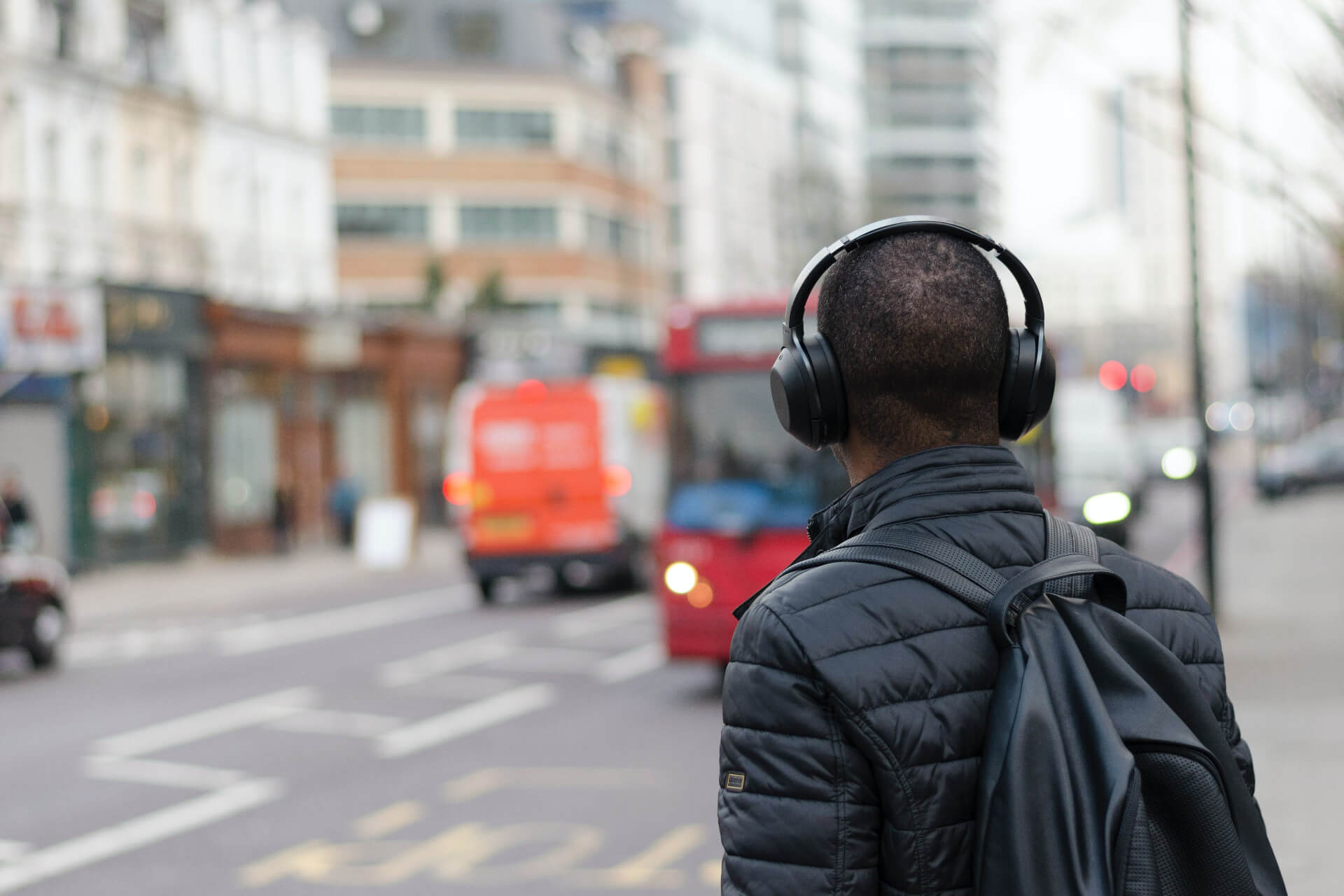 A man walking down a street weating headphones